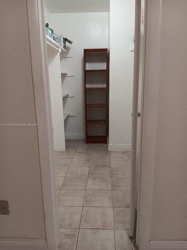 walk in closet with light tile patterned floors