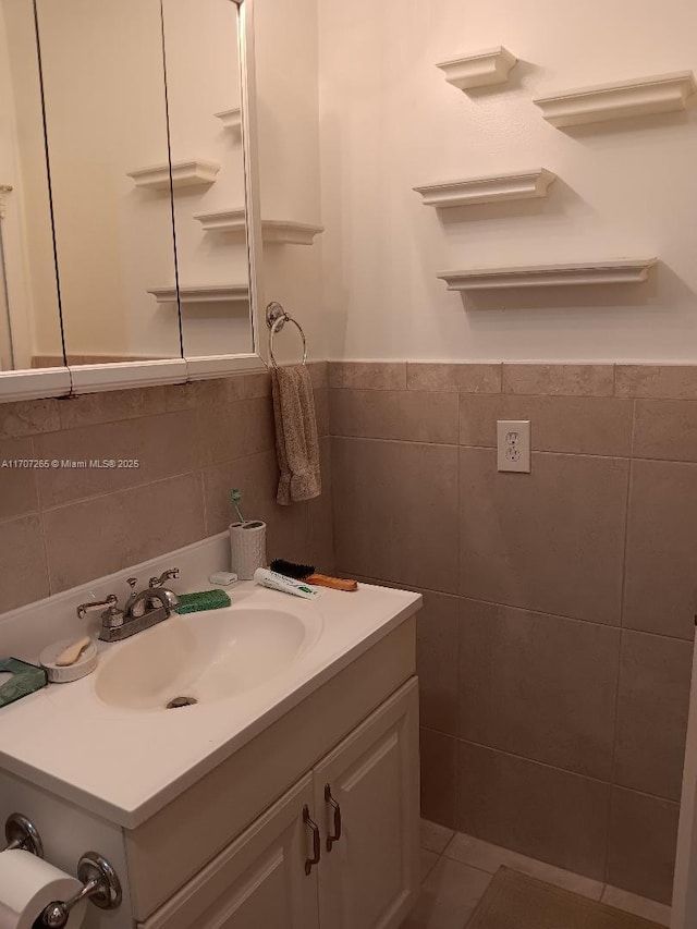 bathroom featuring vanity and tile walls