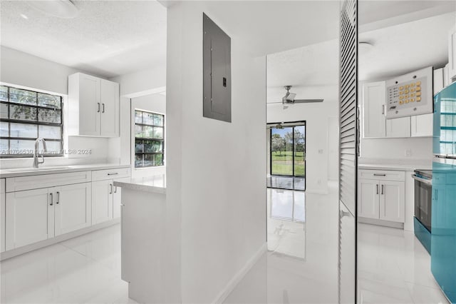 kitchen featuring white cabinets, plenty of natural light, sink, and a textured ceiling