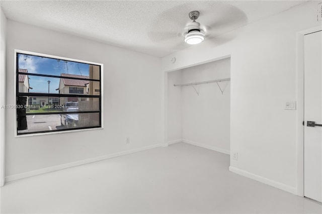 spare room featuring concrete flooring, a textured ceiling, and ceiling fan