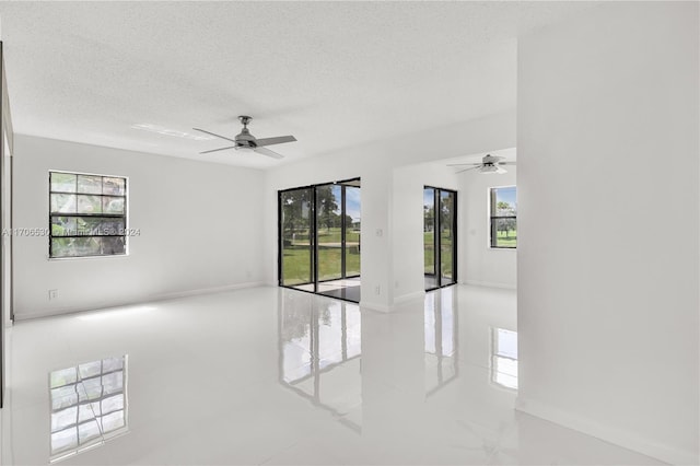 spare room with ceiling fan and a textured ceiling