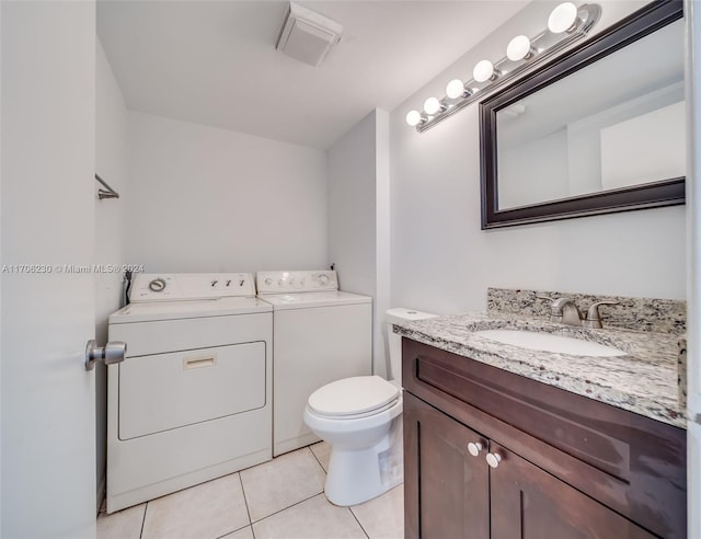 bathroom with washer and dryer, vanity, tile patterned flooring, and toilet