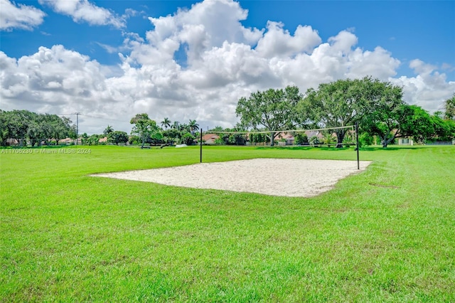 surrounding community with volleyball court and a lawn