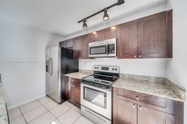 kitchen featuring dark brown cabinets, light tile patterned flooring, and appliances with stainless steel finishes