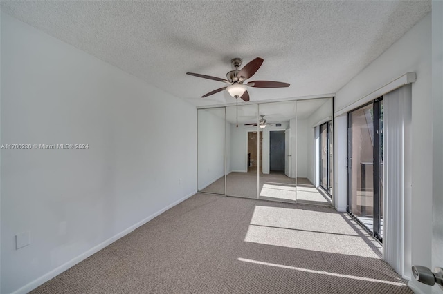 carpeted spare room featuring a textured ceiling and ceiling fan