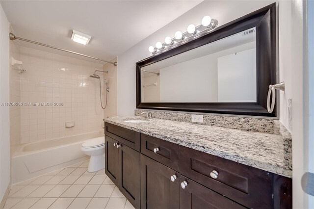 full bathroom with vanity, tiled shower / bath, tile patterned floors, and toilet