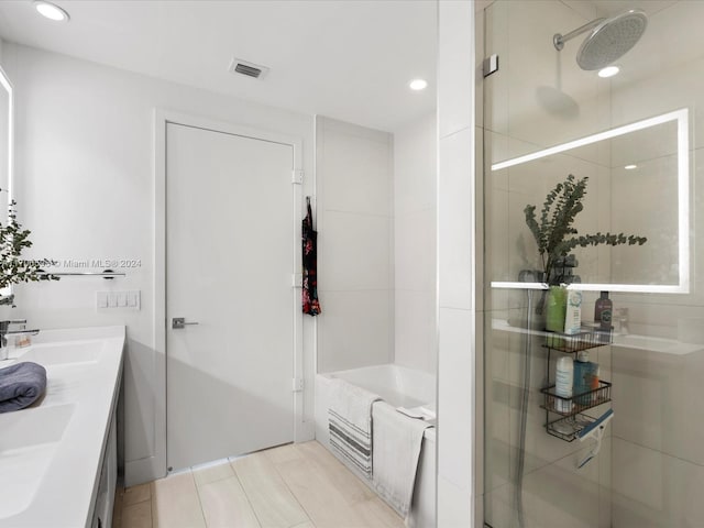 bathroom featuring separate shower and tub and vanity