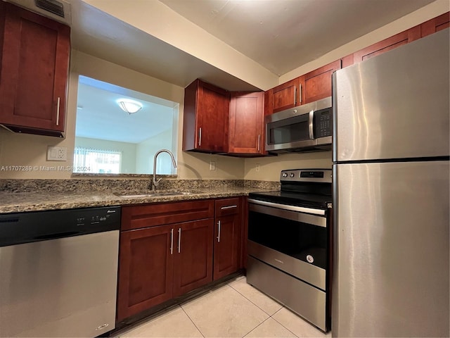 kitchen with sink, light tile patterned floors, and stainless steel appliances