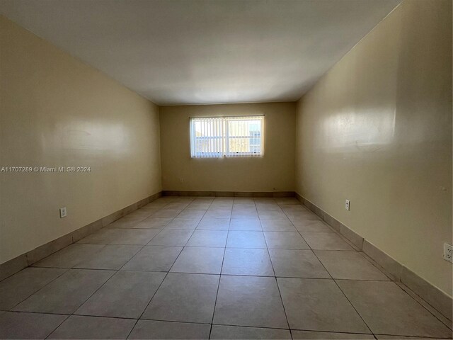 3700 NW 21st St Unit 304, Lauderdale Lakes, FL 33311 - spare room featuring light tile patterned floors and baseboards
