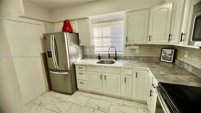 kitchen with sink, white cabinetry, stainless steel appliances, and tasteful backsplash