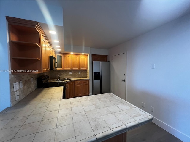 kitchen with a sink, tasteful backsplash, open shelves, tile countertops, and black appliances