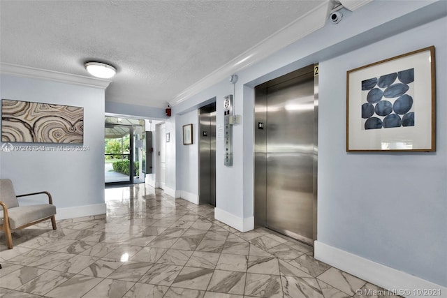 hall with a textured ceiling, crown molding, and elevator