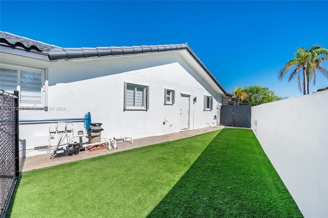 rear view of property featuring a yard and a patio