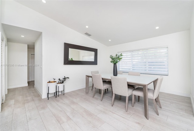 dining room with light wood-type flooring and lofted ceiling