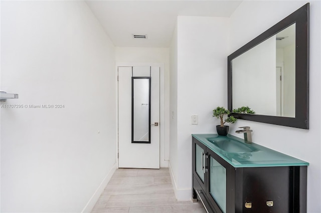 hallway with sink and light hardwood / wood-style flooring