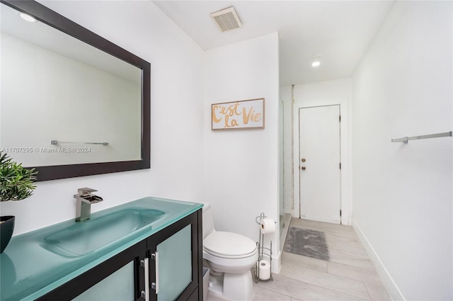 bathroom with hardwood / wood-style flooring, vanity, and toilet