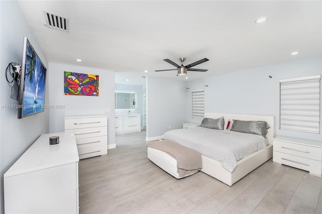 bedroom featuring ensuite bath, ceiling fan, and light hardwood / wood-style flooring