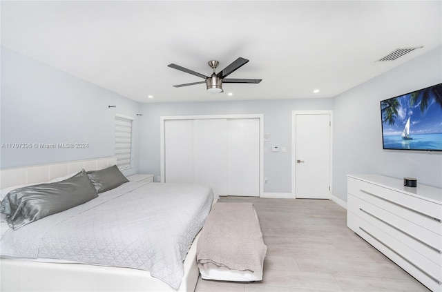 bedroom featuring ceiling fan, light wood-type flooring, and a closet