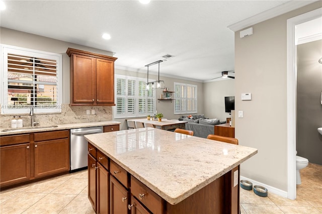 kitchen featuring a center island, sink, stainless steel dishwasher, ceiling fan, and ornamental molding