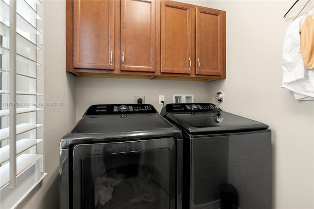 laundry area featuring washing machine and dryer and cabinets