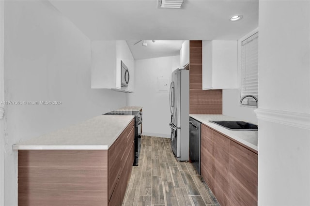 kitchen with sink, appliances with stainless steel finishes, and light hardwood / wood-style flooring