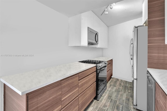 kitchen with appliances with stainless steel finishes, rail lighting, and dark hardwood / wood-style floors