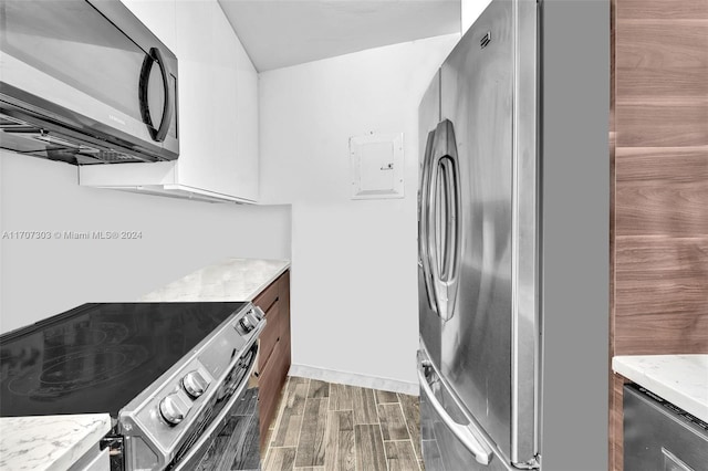 kitchen featuring light stone counters, dark wood-type flooring, and stainless steel appliances