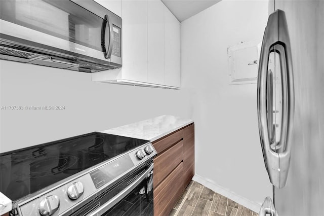 kitchen with white cabinetry, dark wood-type flooring, and appliances with stainless steel finishes