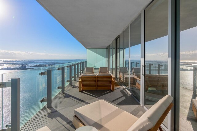 balcony with outdoor lounge area and a water view