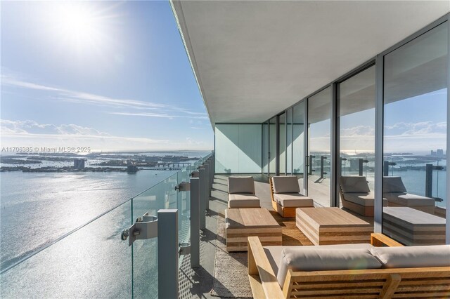 balcony with an outdoor living space and a water view