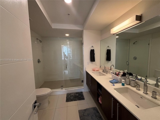 bathroom with a raised ceiling, tile patterned flooring, toilet, a shower with door, and vanity