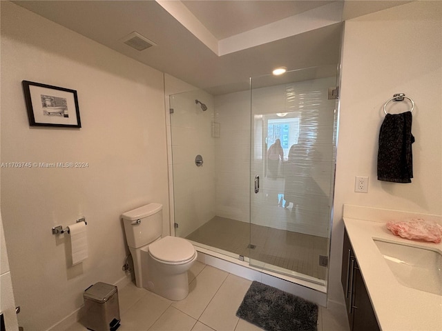 bathroom with toilet, vanity, tile patterned floors, and a shower with shower door