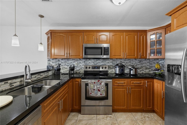 kitchen featuring pendant lighting, sink, appliances with stainless steel finishes, and tasteful backsplash