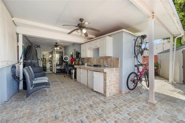 kitchen featuring tasteful backsplash, ceiling fan, and white cabinets