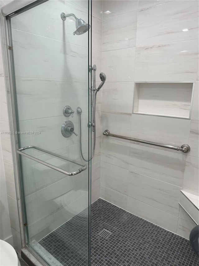 bathroom featuring a shower with door