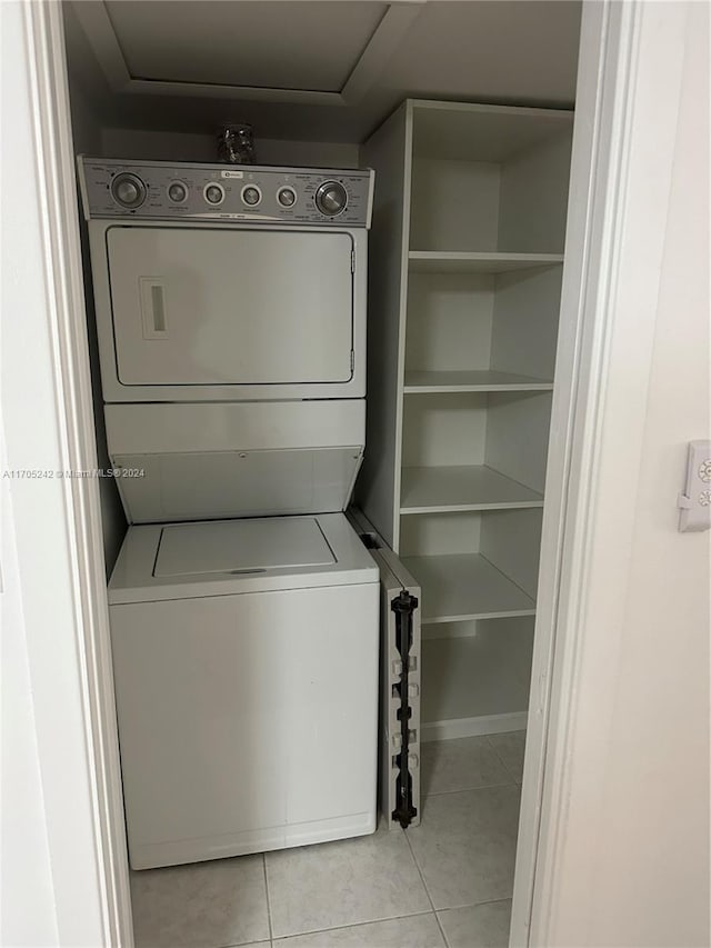 washroom featuring light tile patterned flooring and stacked washer and dryer