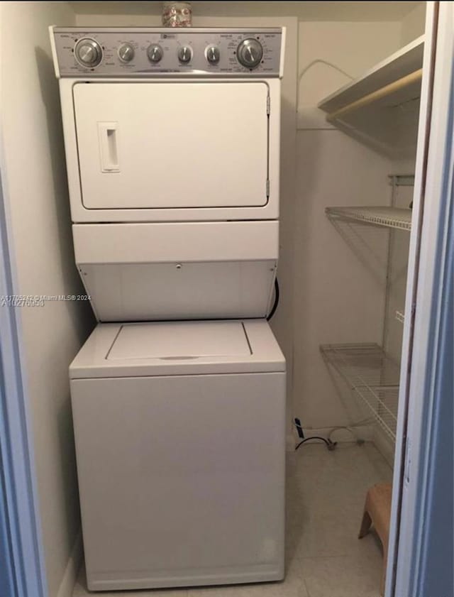 10210 Collins Ave Unit 306, Bal Harbour, FL 33154 - laundry area featuring stacked washer and clothes dryer and light tile patterned floors