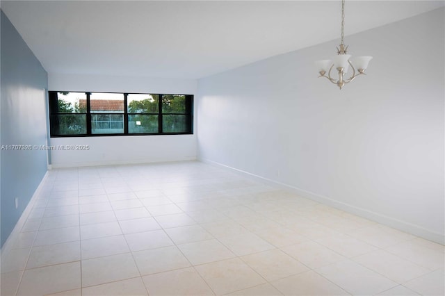 tiled empty room featuring an inviting chandelier