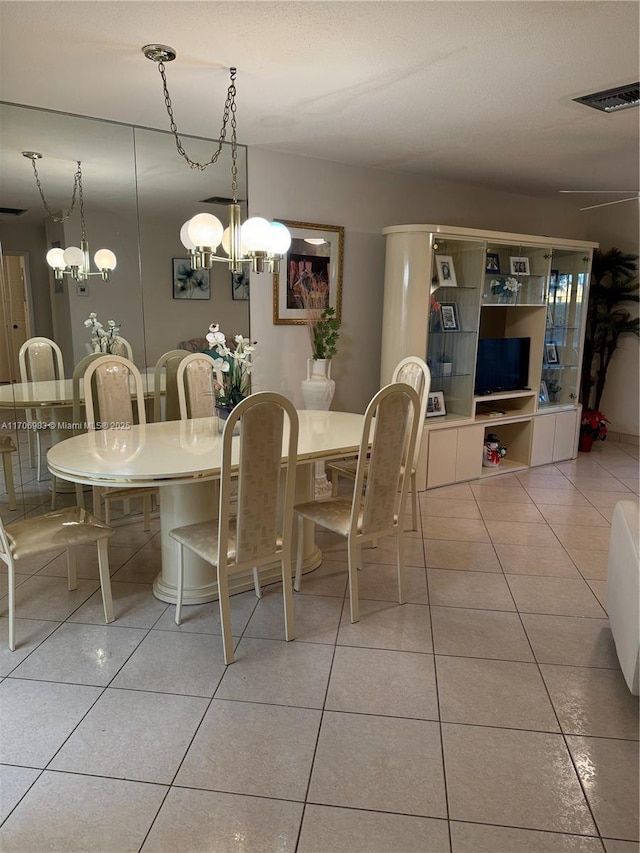 tiled dining room with an inviting chandelier