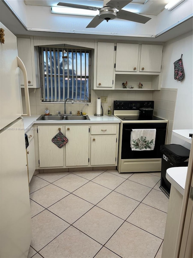 kitchen with range with electric cooktop, white refrigerator, light tile patterned flooring, and sink