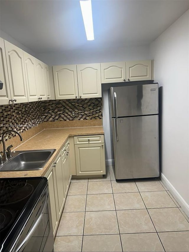 kitchen featuring decorative backsplash, sink, light tile patterned floors, and stainless steel appliances