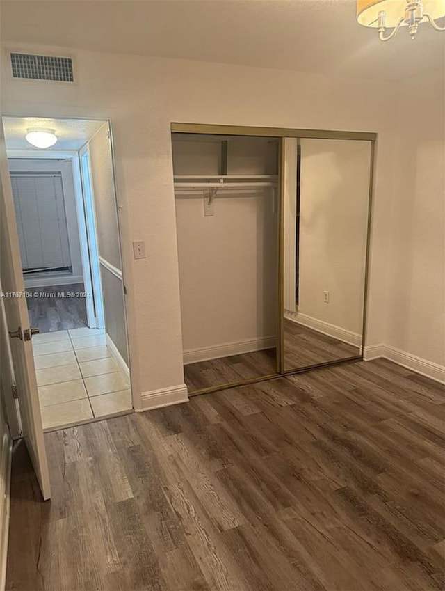 unfurnished bedroom with a closet and dark hardwood / wood-style flooring