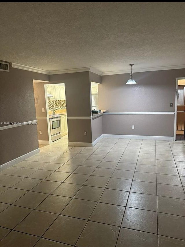 tiled spare room featuring crown molding and a textured ceiling