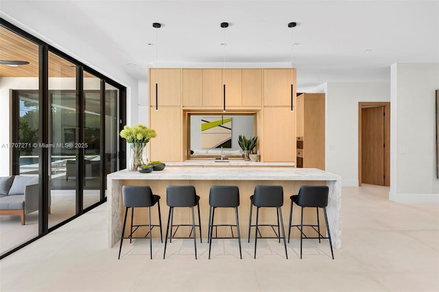 kitchen featuring pendant lighting, light tile patterned floors, and a breakfast bar area