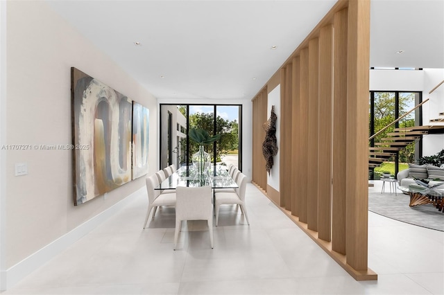 dining space with floor to ceiling windows and light tile patterned floors