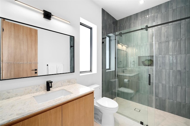 bathroom with an enclosed shower, vanity, and toilet