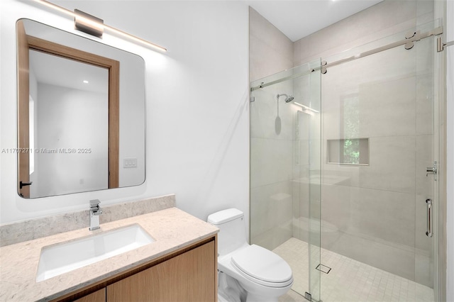 bathroom with toilet, an enclosed shower, and vanity