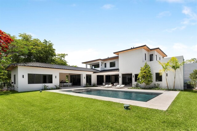 view of pool with a lawn, a patio area, and an in ground hot tub