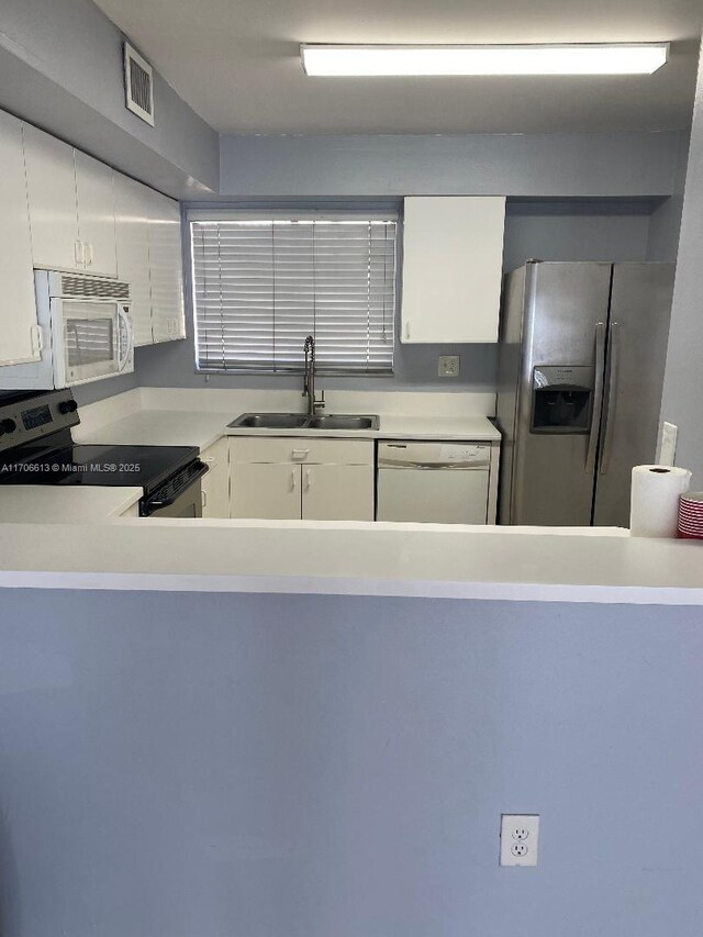 kitchen featuring white cabinets, appliances with stainless steel finishes, light tile patterned floors, and sink