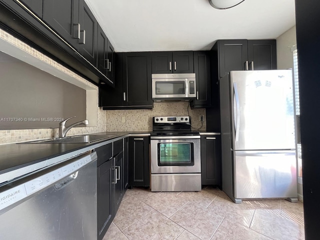 kitchen with backsplash, sink, light tile patterned floors, and stainless steel appliances